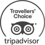 An image showing the TripAdvisor logo with circular badge and goggles icon, plus the text “Travelers’ Choice” and “tripadvisor,” all in grayscale.